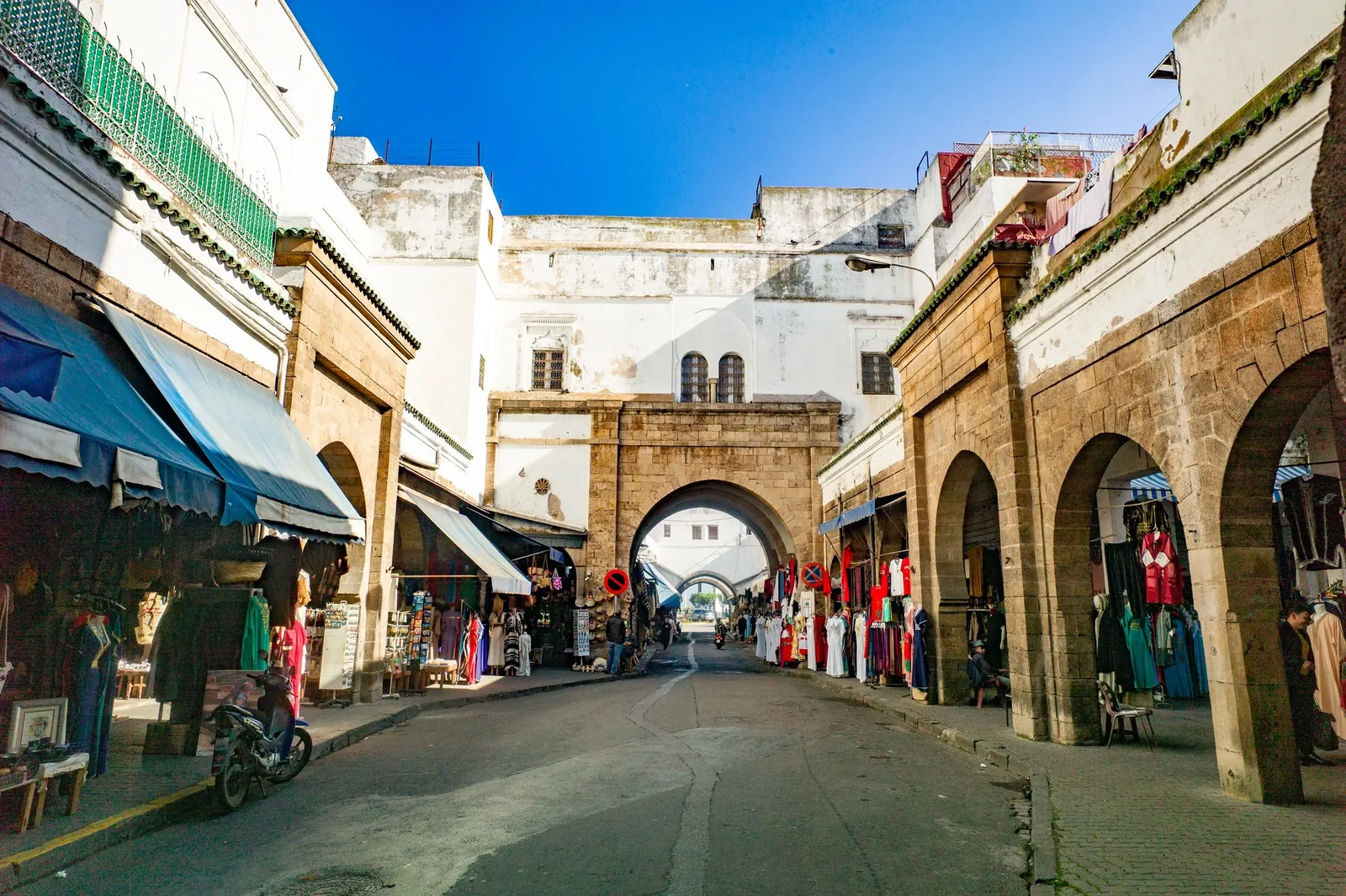 Stone archway and traditional clothing shops in Casablanca's Habous Quarter market
