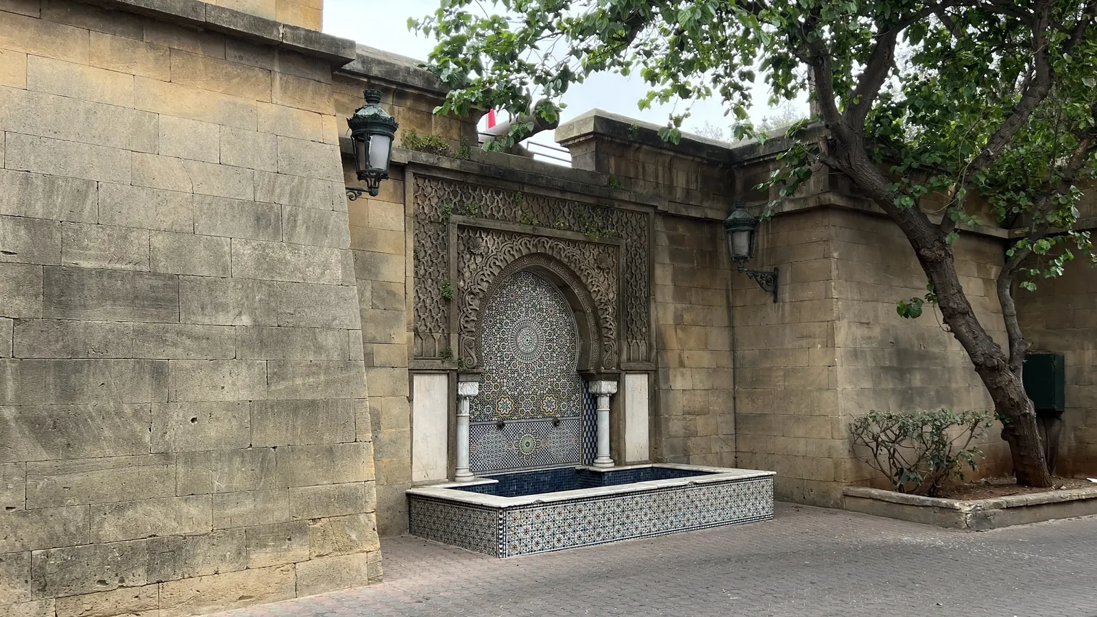 Ornate tiled Moroccan wall fountain with a carved archway in the Habous Quarter, Casablanca