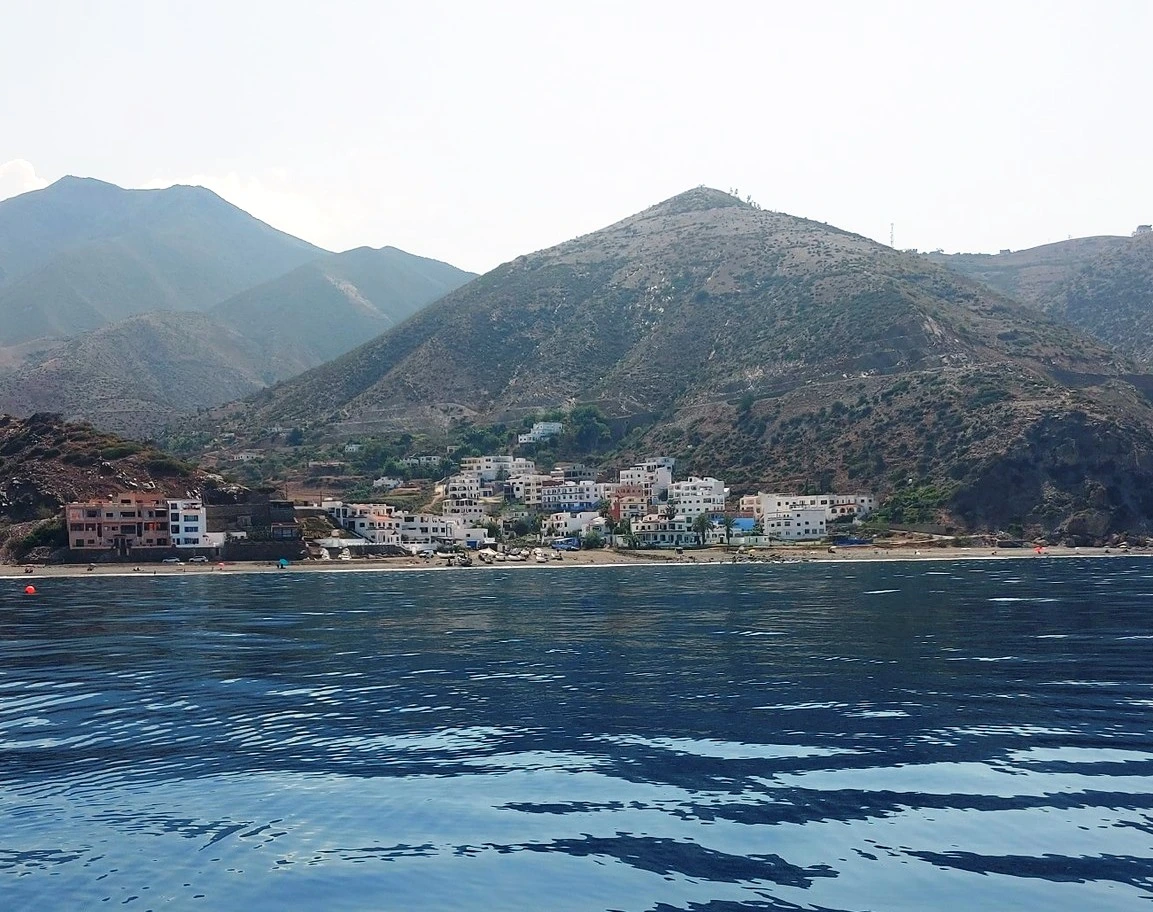 Discover Jnan Nich Beach, a hidden black sand paradise in northern Morocco. Crystal clear waters, dramatic cliffs, and authentic Berber culture await.