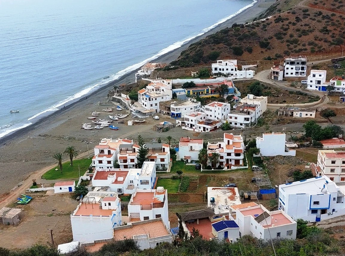Discover Jnan Nich Beach, a hidden black sand paradise in northern Morocco. Crystal clear waters, dramatic cliffs, and authentic Berber culture await.
