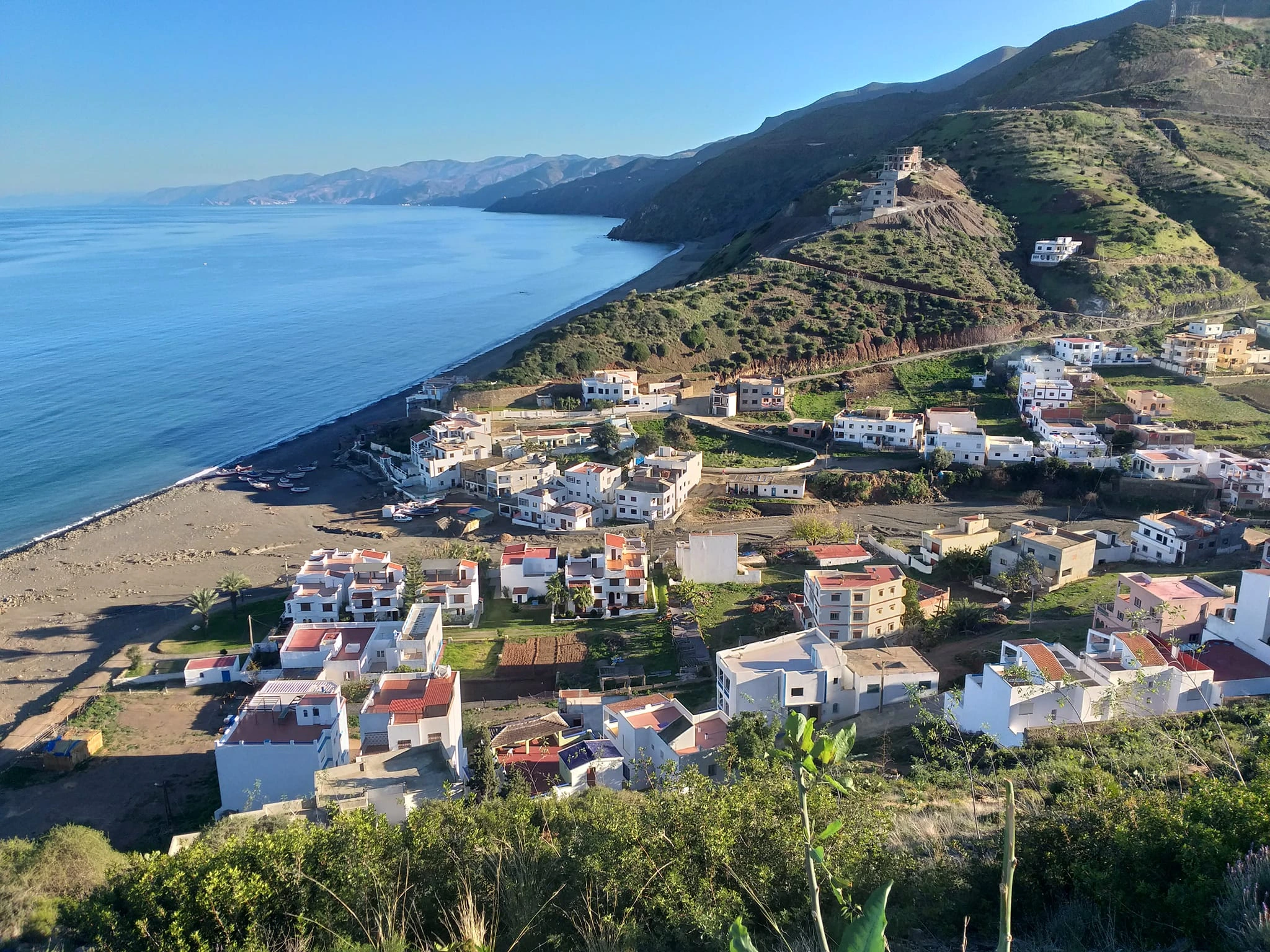 Discover Jnan Nich Beach, a hidden black sand paradise in northern Morocco. Crystal clear waters, dramatic cliffs, and authentic Berber culture await.